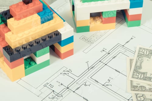 Preview: Small houses made of toy blocks, electrical diagrams of house and dollar banknotes.