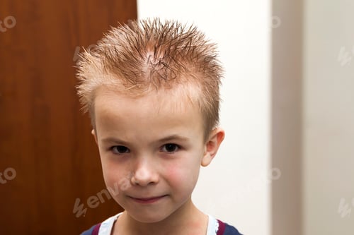 Preview: Portrait of a boy with wet hair after taking a shower of bath. Funny boy with crazy hairstyle.