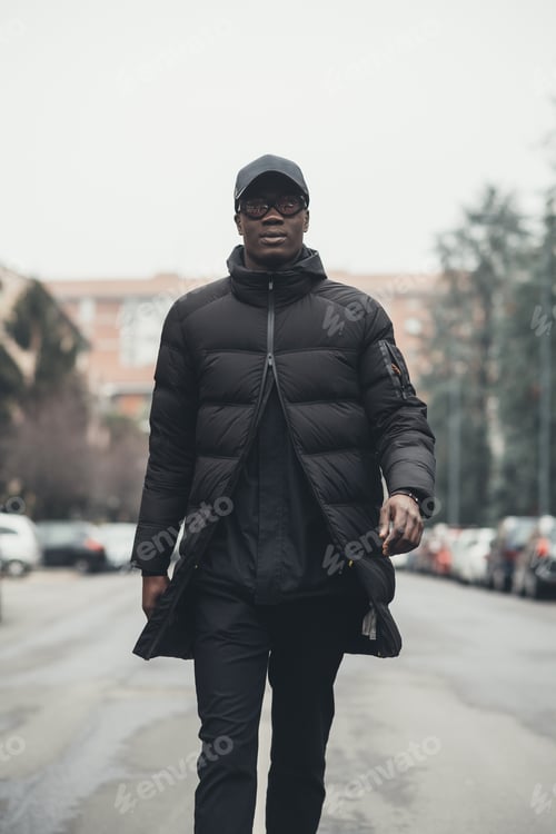 Preview: young bearded african man outdoors walking looking camera
