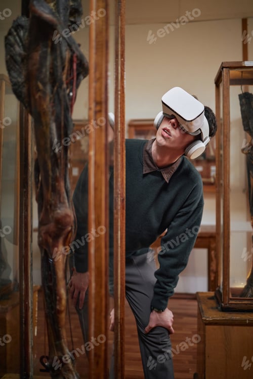 Preview: Young Adult Caucasian Man Wearing Virtual Reality Headset Exploring Museum Exhibit