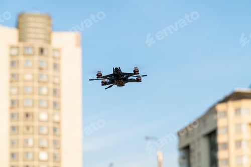 Preview: A small sports drone reconnaissance flies in the air among the buildings in the city