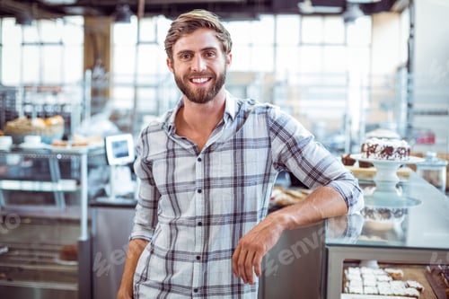 Preview: Selfassured waiter smiling in front of his bakery
