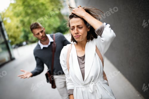 Preview: Sad young woman and man outdoor on street having relationship problems