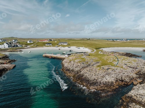 Preview: Aerial view of a sandy beach along Tiree island in Scotland with houses and a turquoise sea lagoon