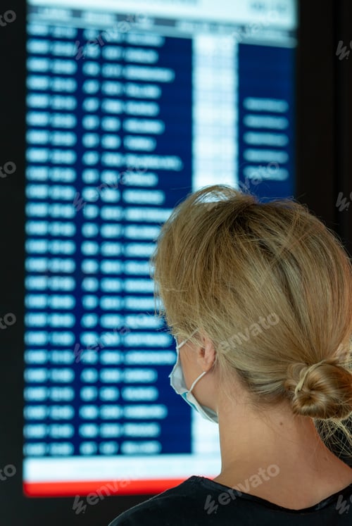 Preview: Woman looking on the display with information about a flights in an airport