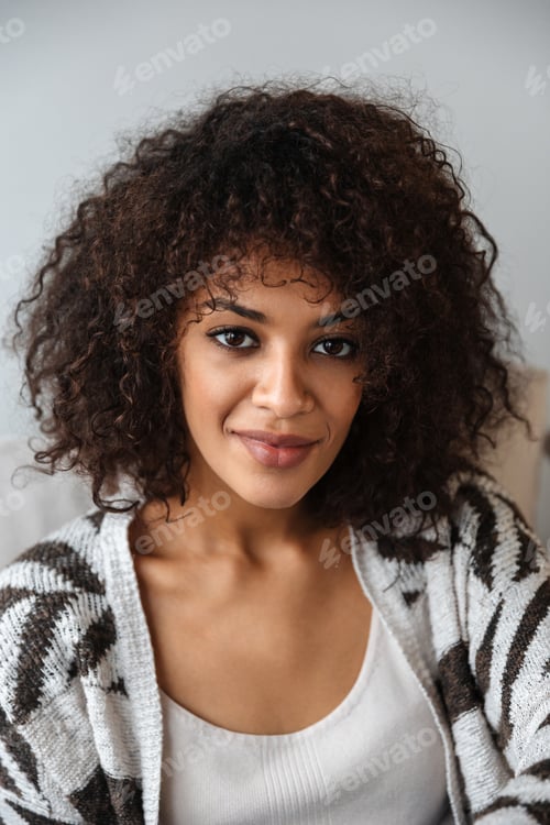 Preview: Optimistic beautiful young african woman indoors at home.