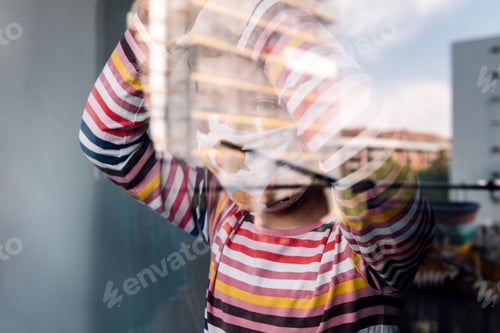 Preview: kid with mask looking through the window
