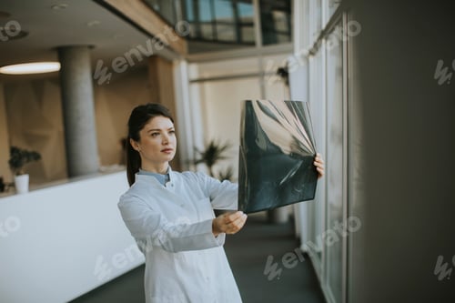 Preview: Yyoung female doctos examining x-ray image in the office
