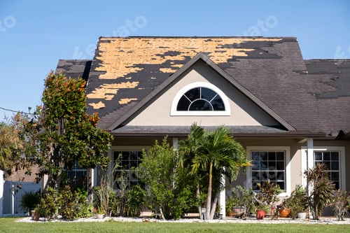 Preview: Wind damaged house roof with missing asphalt shingles after hurricane Ian in Florida.