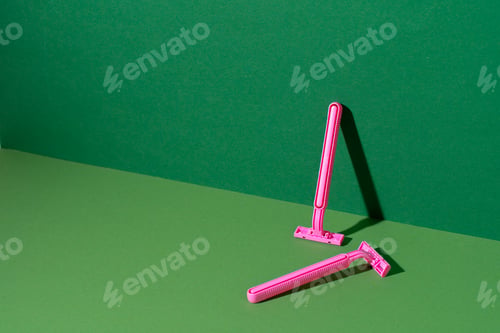 Preview: Disposable razor on green background, studio shot