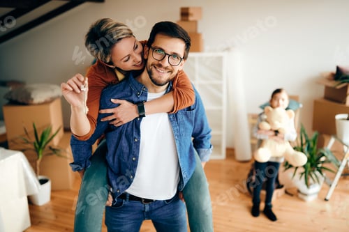 Aperçu: Happy parents having fun while moving into a new home with their daughter.