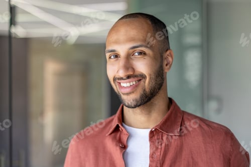 Preview: Confident young man smiling in a modern office setting