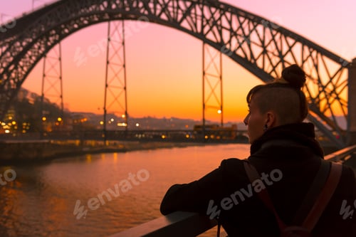Preview: Woman looking at river and city in evening