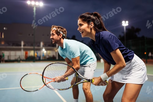 Preview: Tennis sport people concept. Mixed doubles player hitting tennis ball with partner standing near net