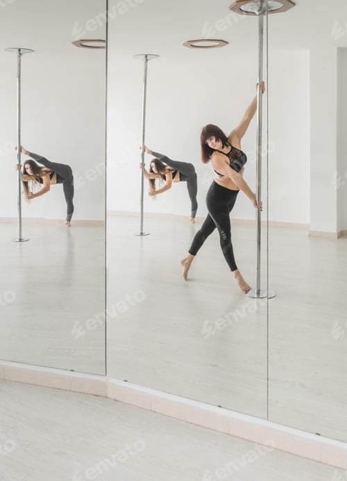 Preview: Flexible women dancing near pole in studio