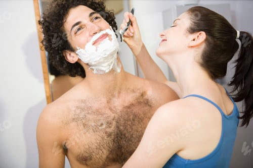 Preview: A woman carefully shaves a man with a playful smile
