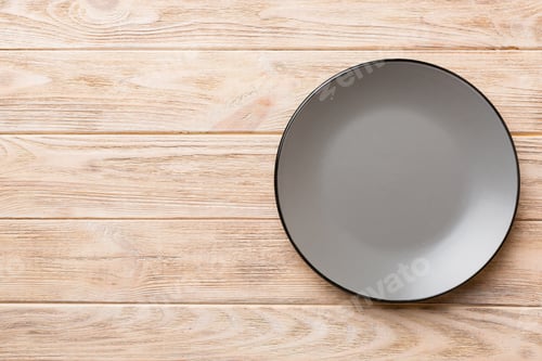 Preview: Top view of empty grey plate on wooden background. Empty space for your design
