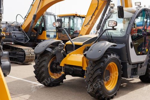 Preview: New mini excavators in the same row in the agricultural machinery store.