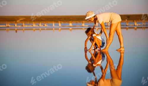 Preview: Two fantastically beautiful girls on a beautiful transparent lake are looking for something in a