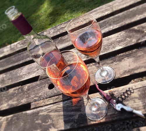 Preview: Bottle and Glasses of Rosé Wine on Wood
