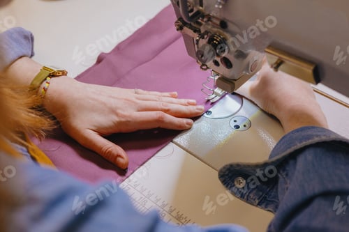 Preview: woman sews piece of cloth on sewing machine. industrial metal machine for all fabric tops.