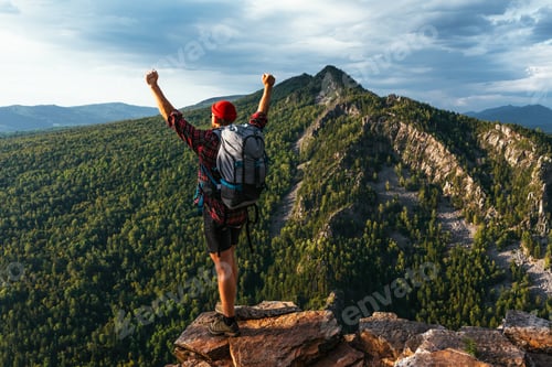 Preview: A man with a backpack in the mountains at sunset, rear view. A trip to the mountains with a backpack