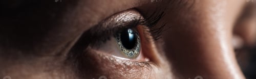 Preview: close up view of human eye looking away in dark, panoramic shot