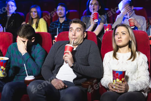Preview: Young scared couple at the cinema watching an horror movie