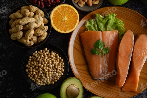Preview: Legumes, fruit and salmon pieces on a wooden plate.