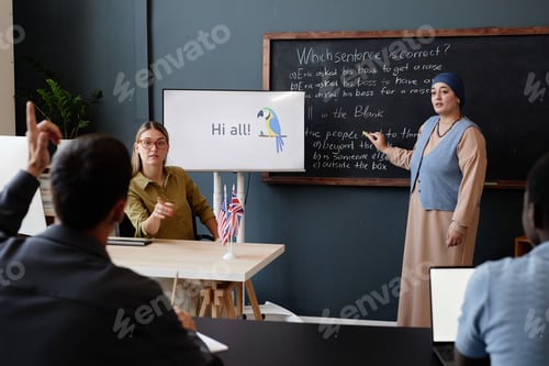 Preview: Muslim Woman Explaining Task Standing at Blackboard in Class at English Language School