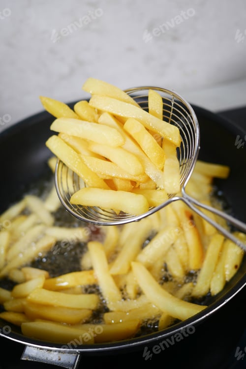 Preview: Crispy and Golden French Fries Being Deep Fried to Perfection for a Delicious Snack