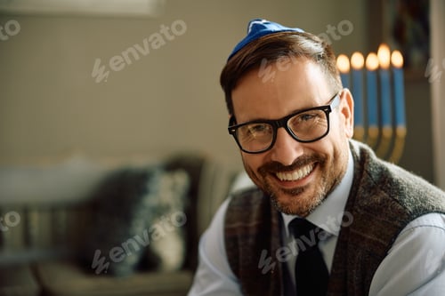 Preview: Happy Jewish man at home on Hanukkah looking at camera.