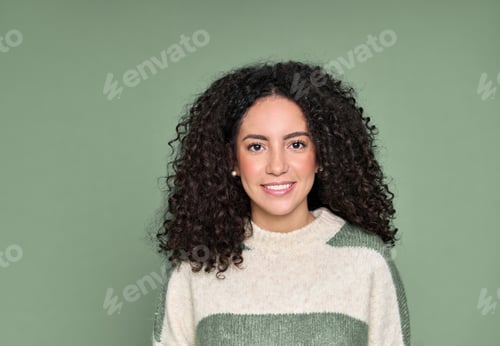 Preview: Young smiling latin woman standing isolated on green background, portrait.