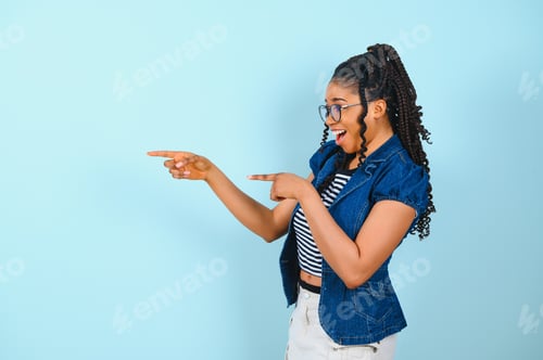 Preview: Check this offer. Positive black lady pointing fingers at free space looking and smiling at camera