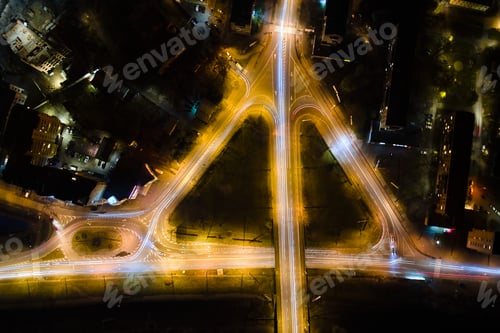 Preview: Aerial view of road intersection with fast moving heavy traffic at night. Top view of urban