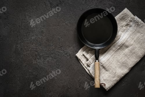 Preview: Empty small portioned frying pan on a black stone table. Dark Cooking background