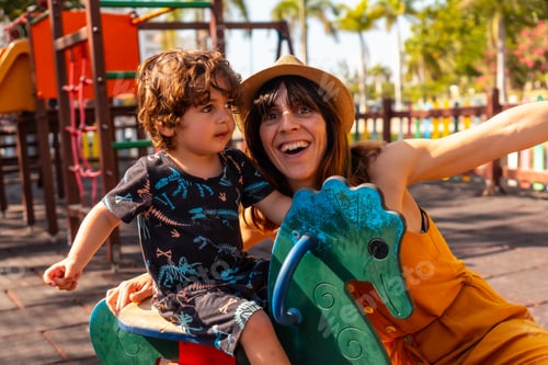 Preview: Mother having fun with her son in a playground on summer vacation