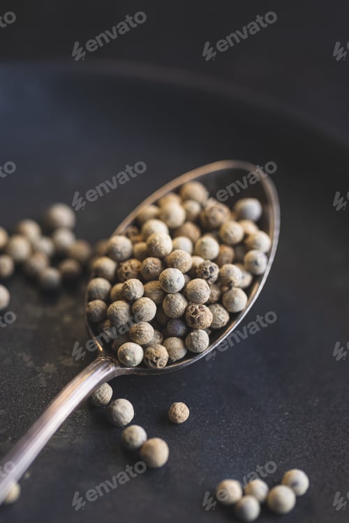 Preview: Whole pepper spice. White peppercorn grain in spoon