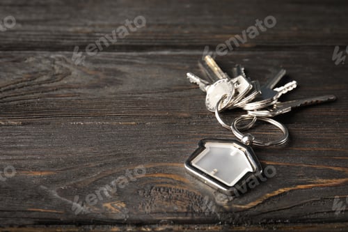 Preview: Bunch of house keys and trinket on wooden background. Space for text