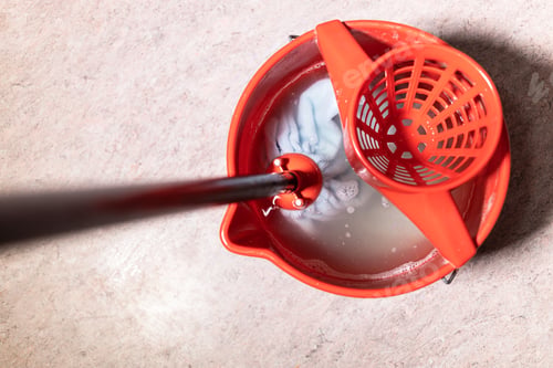 Preview: top view of mop rinsing in red bucket with water