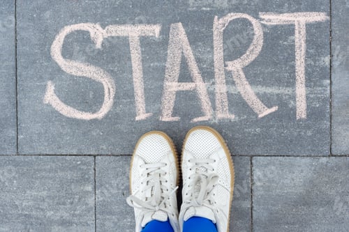 Preview: Teenager girl standing legs on sidewalk in front of word hand written chalk start