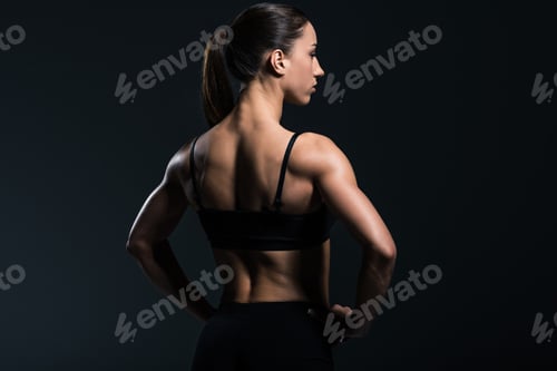 Preview: back view of beautiful bodybuilder with muscular body in sportswear, isolated on grey