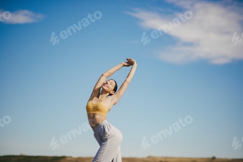 Preview: Woman Stretching Outdoors under a Clear Sky