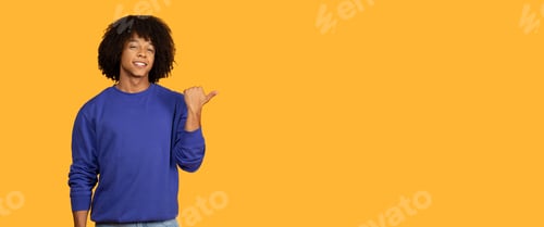 Preview: Smiling Man In Blue Sweatshirt Pointing Right Against Yellow Background