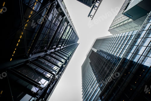 Preview: Low angle shot of many tall buildings in a city at night with the lights on