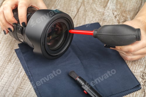 Preview: The photographer cleans the lens of the lens from dust.