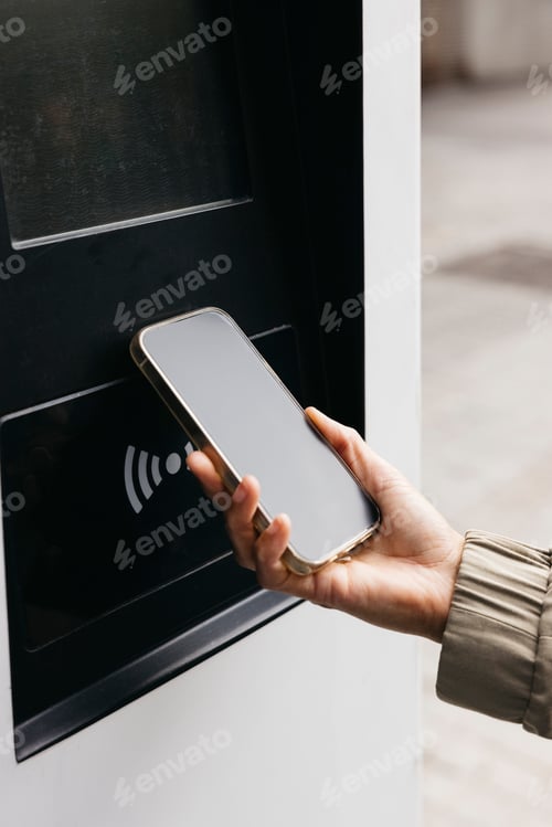 Preview: Hand holding a phone making a contactless payment.
