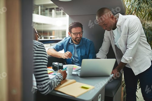 Preview: Creative Team Collaborating on a Laptop in Workplace