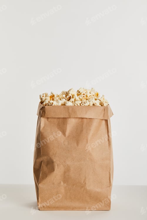 Preview: delicious popcorn in paper bag isolated on grey