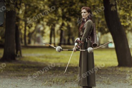 Preview: Warrior medieval woman with bow hunting in green forest